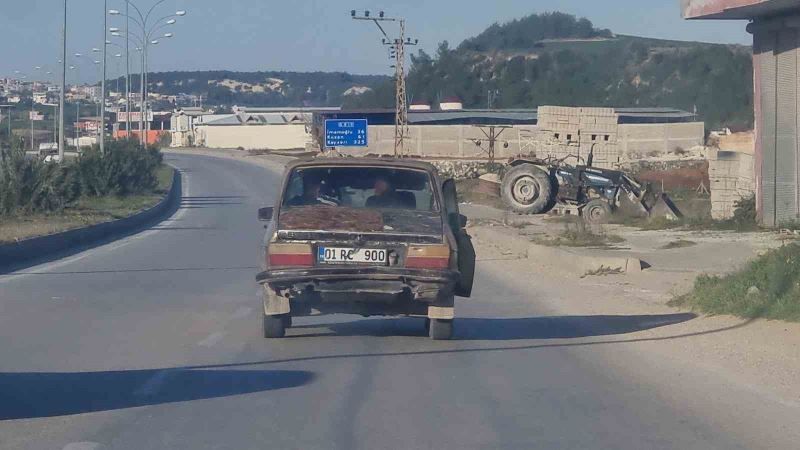 Kapısı açık halde seyreden eski otomobilin trafikte tehlikeli yolculuğu
